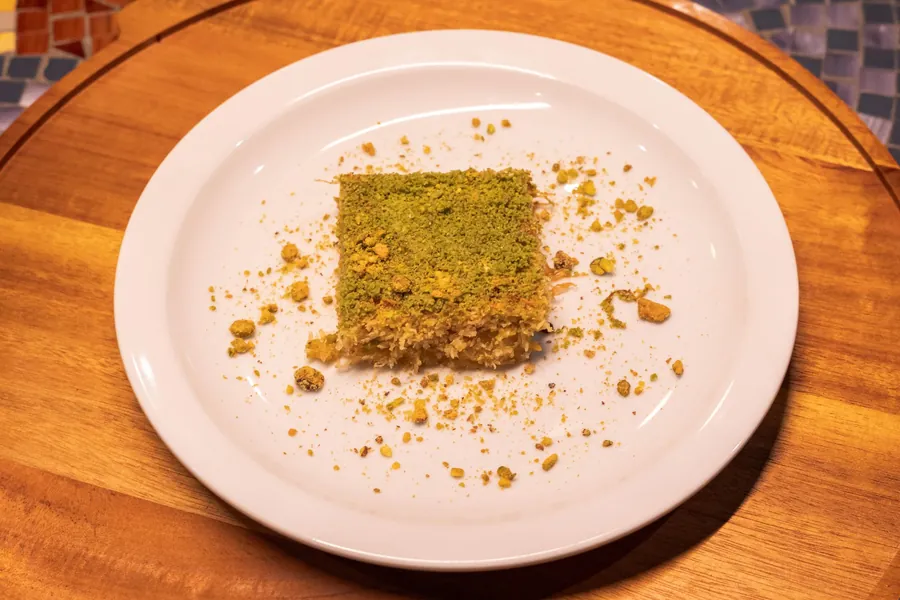 Square of shredded pastry covered in ground pistachio