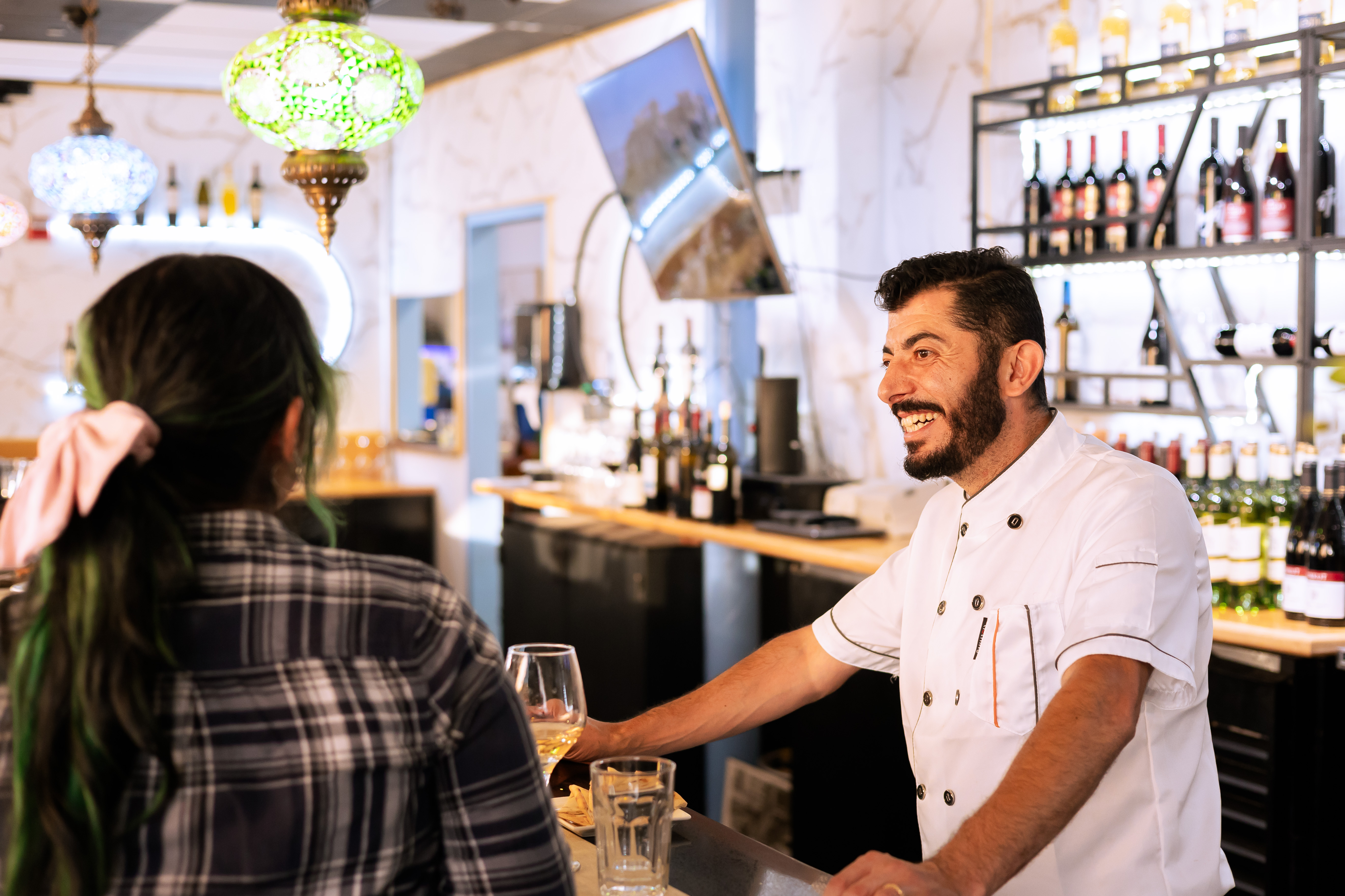 Chef greeting a guest at the bar at Kalimera Bar & Grill in downtown Santa Rosa