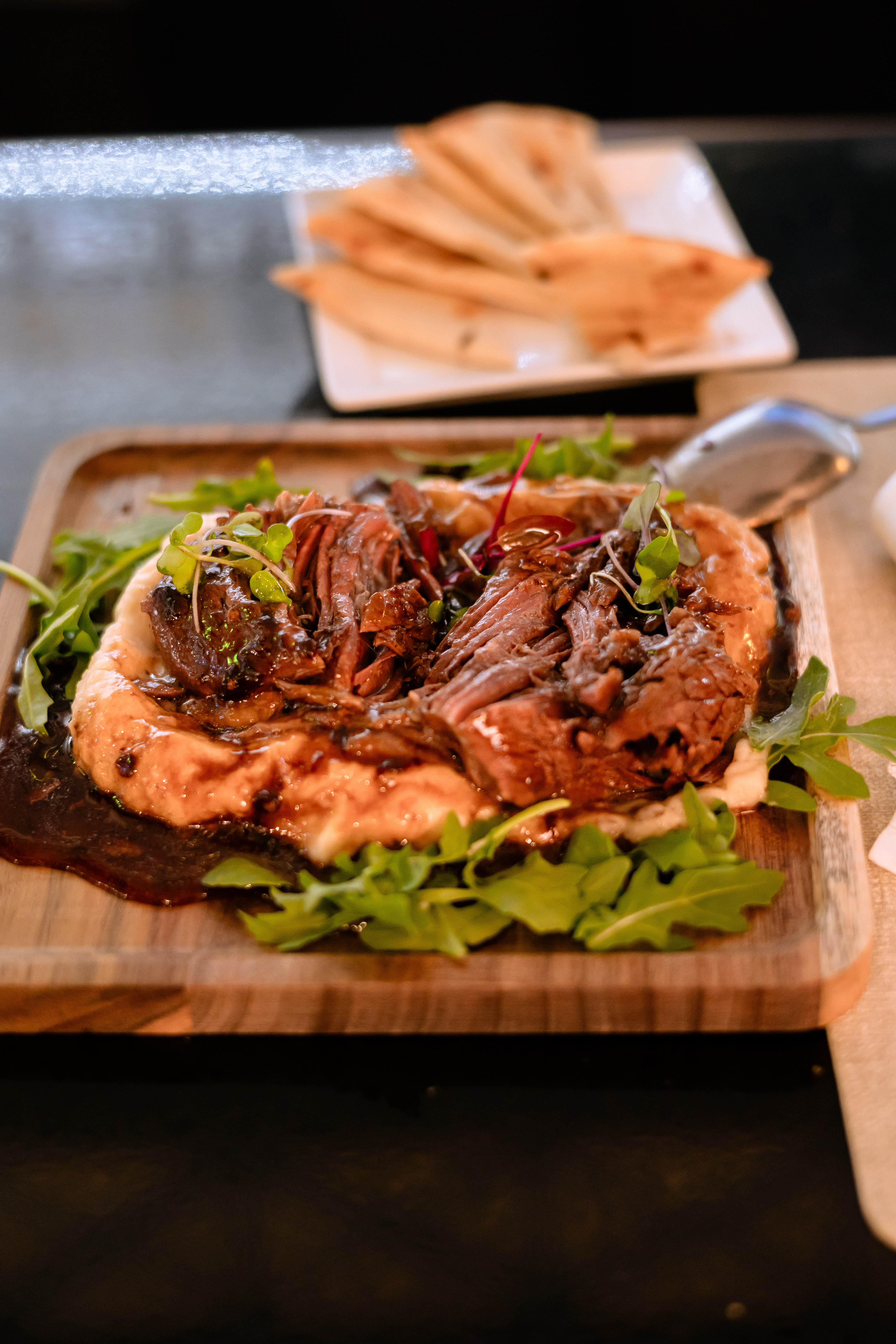 Sliced cabernet braised lamb shank over hummus at Kalimera Bar & Grill